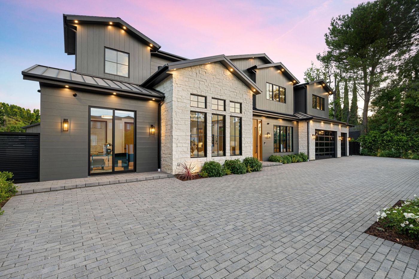 Modern farmhouse exterior painted in warm greige with black trim at dusk
