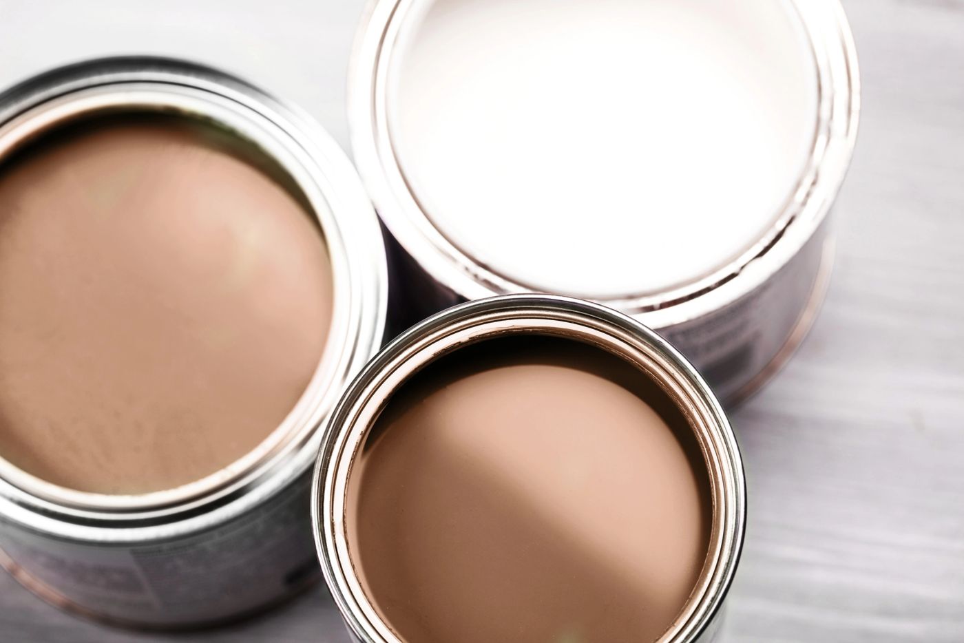 Open paint cans in warm brown and white tones